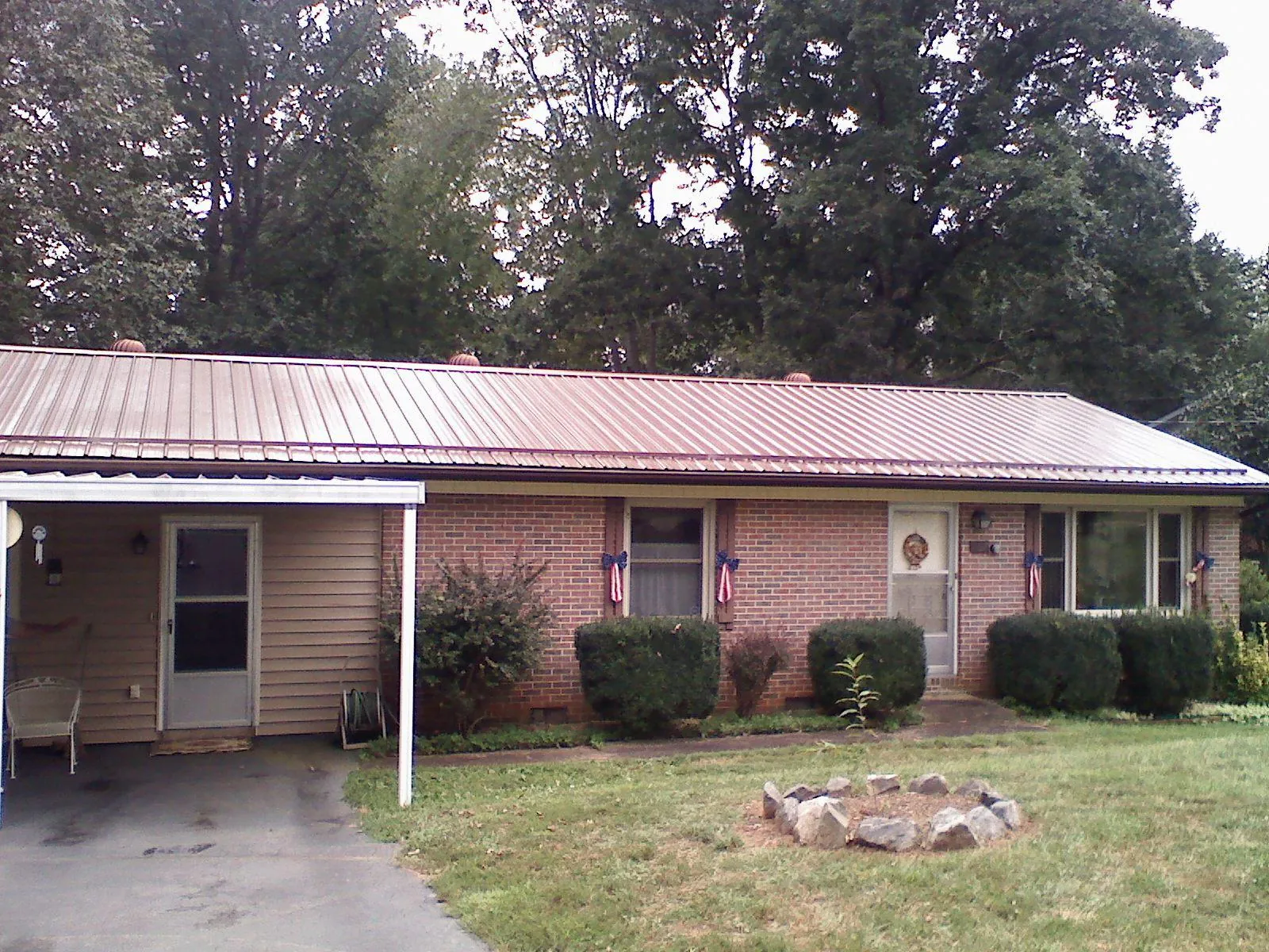 Bronze metal roof and carport on a brick ranch home — Roof Repair work by our crew in Grasston